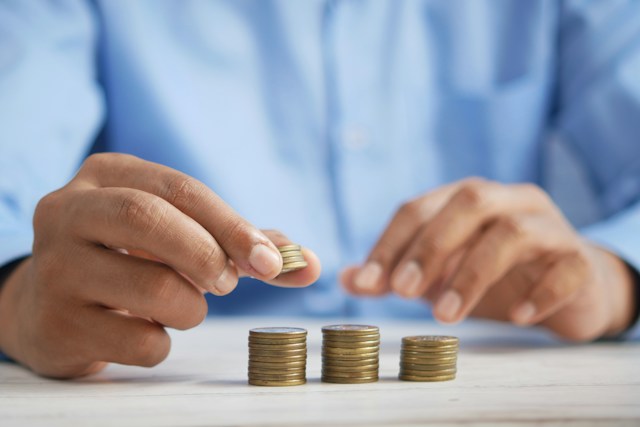 A pair of hands stacking coins.