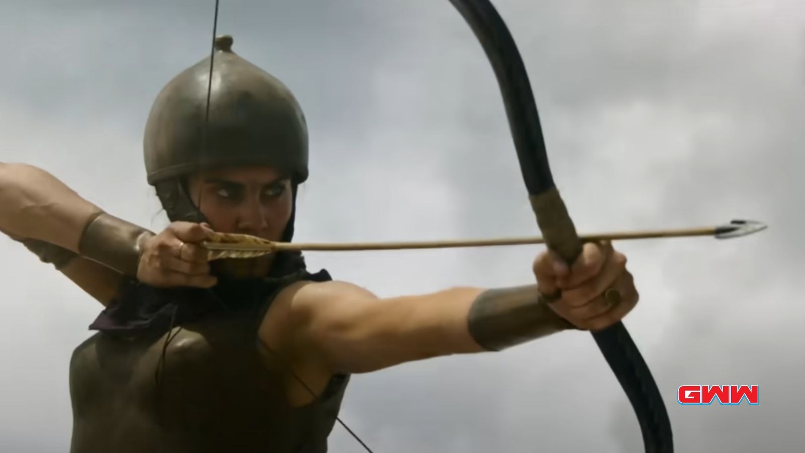 An archer in ancient armor aiming a bow and arrow.