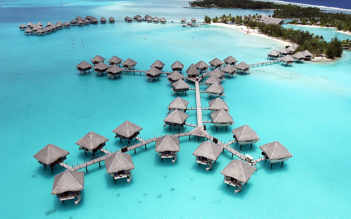 luxurious resorts and bungalows raised above ocean.