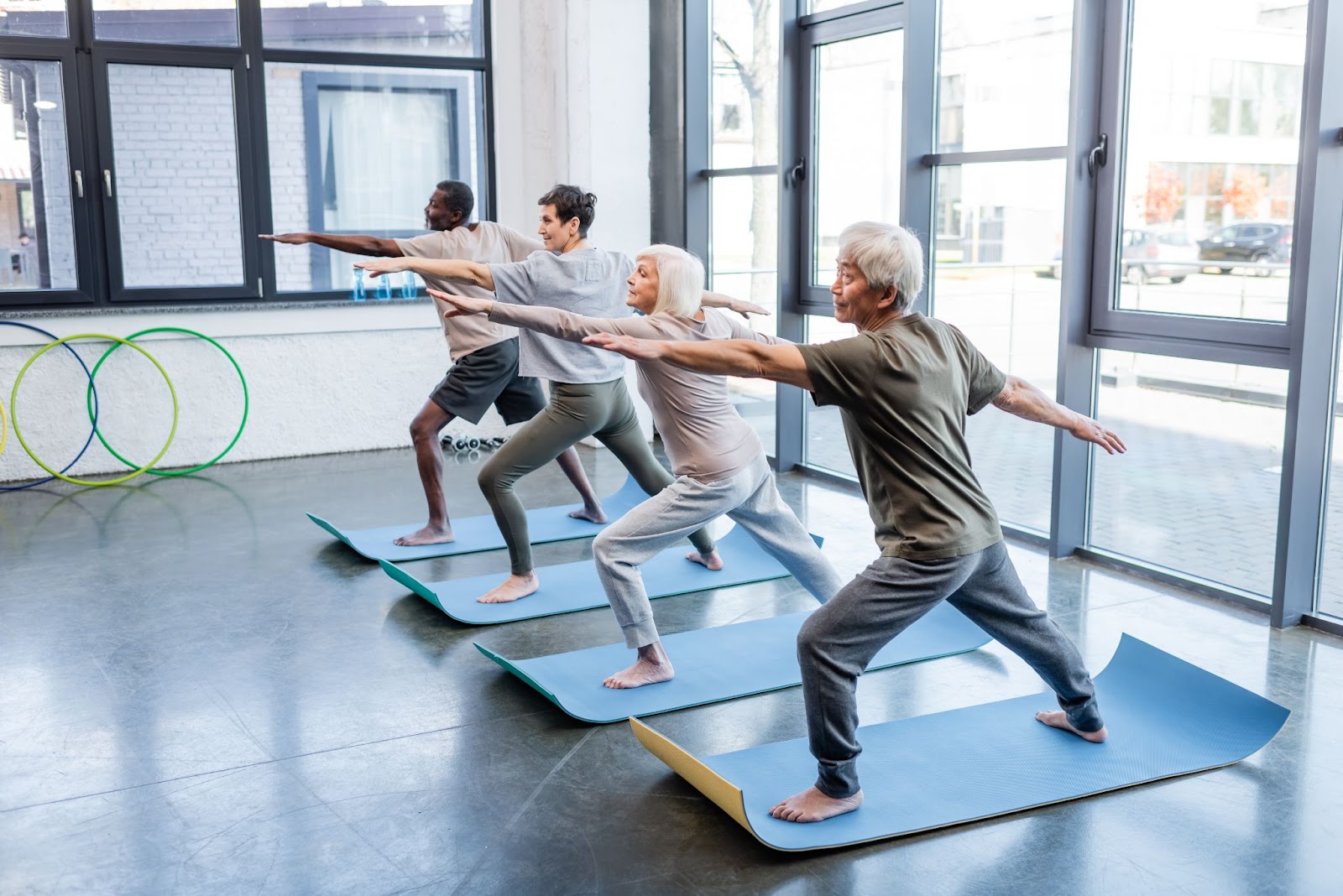 A group of older adults practicing yoga in a fitness class.