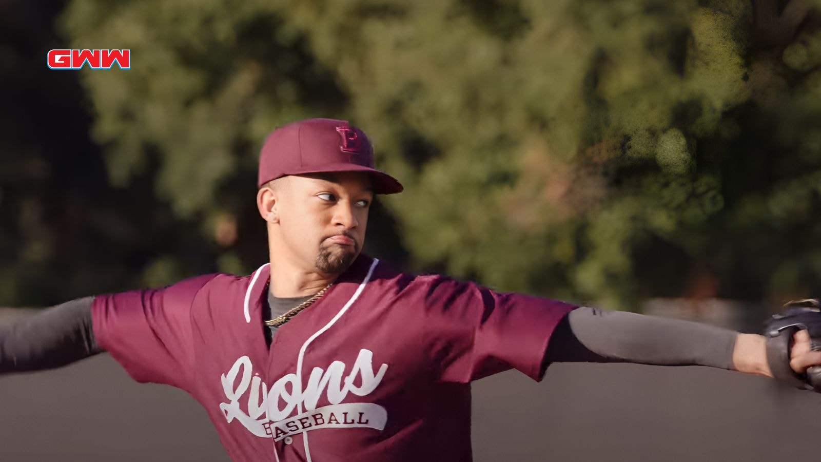 Damon pitching in a maroon Lions baseball uniform, focused on the throw.