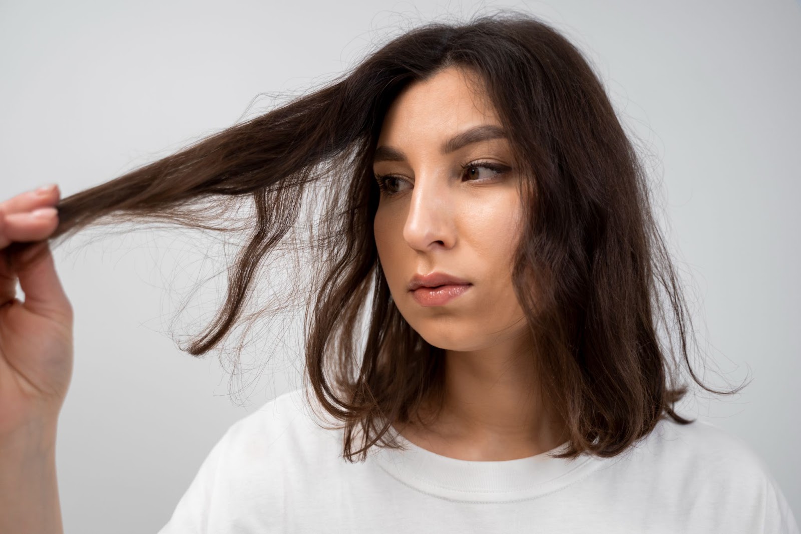 Mulher olhando o cabelo danificado