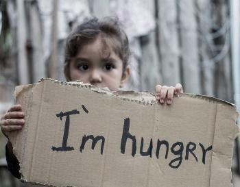 A child holding a cardboard sign

Description automatically generated