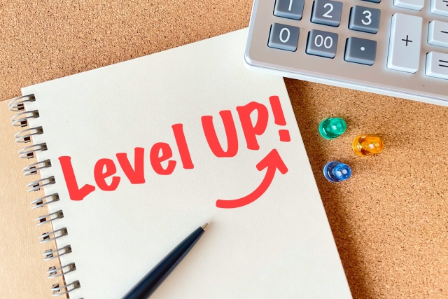 赤文字でlevelup！と書かれたノートと電卓が置いてある様子