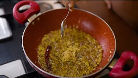 Sautéing onions, ginger, green chili, and kasoori methi in mustard oil for Punjabi Kadhi Pakora.