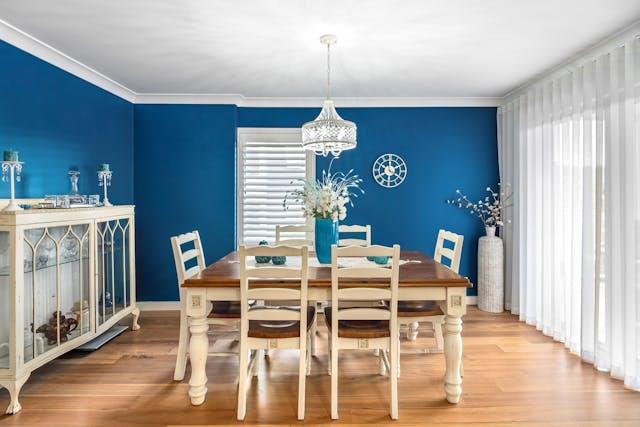 A kitchen with blue walls and white furniture
