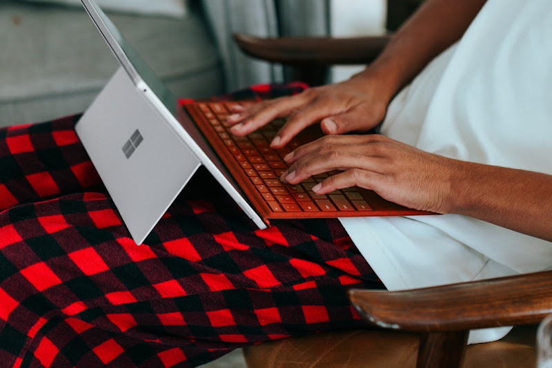 A man using a laptop to conduct a search, prompting the question 'How is Microsoft Search different?'