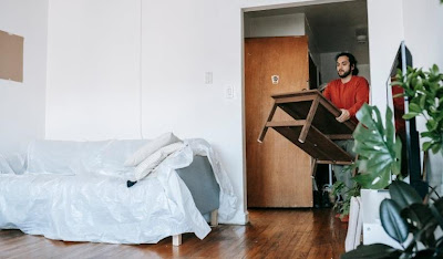 Man carrying a wooden table into a room