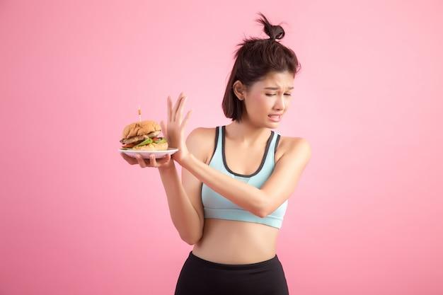 Free photo asian women refuse fast food because of slimming on pink