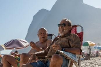 A group of men sitting on chairs at the beach

Description automatically generated