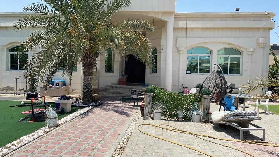 A white house with a brick walkway and palm trees

Description automatically generated