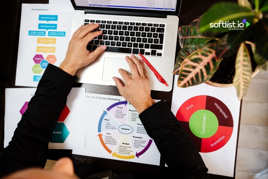 Person working on a laptop with marketing charts.