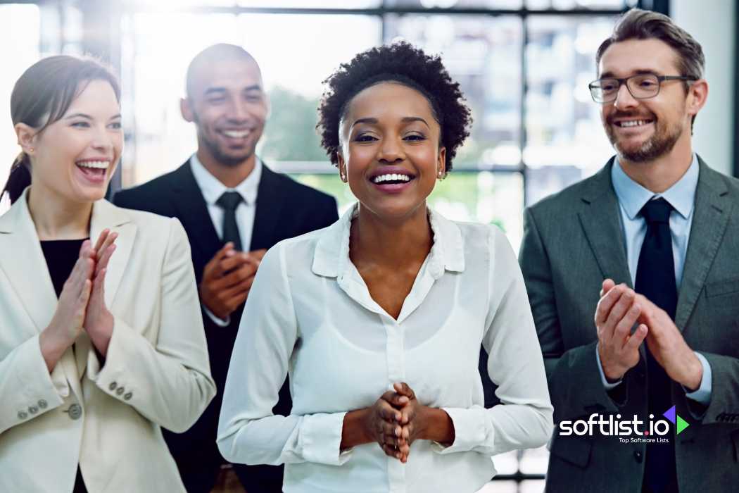 Happy businesswoman applauded by colleagues in a bright office