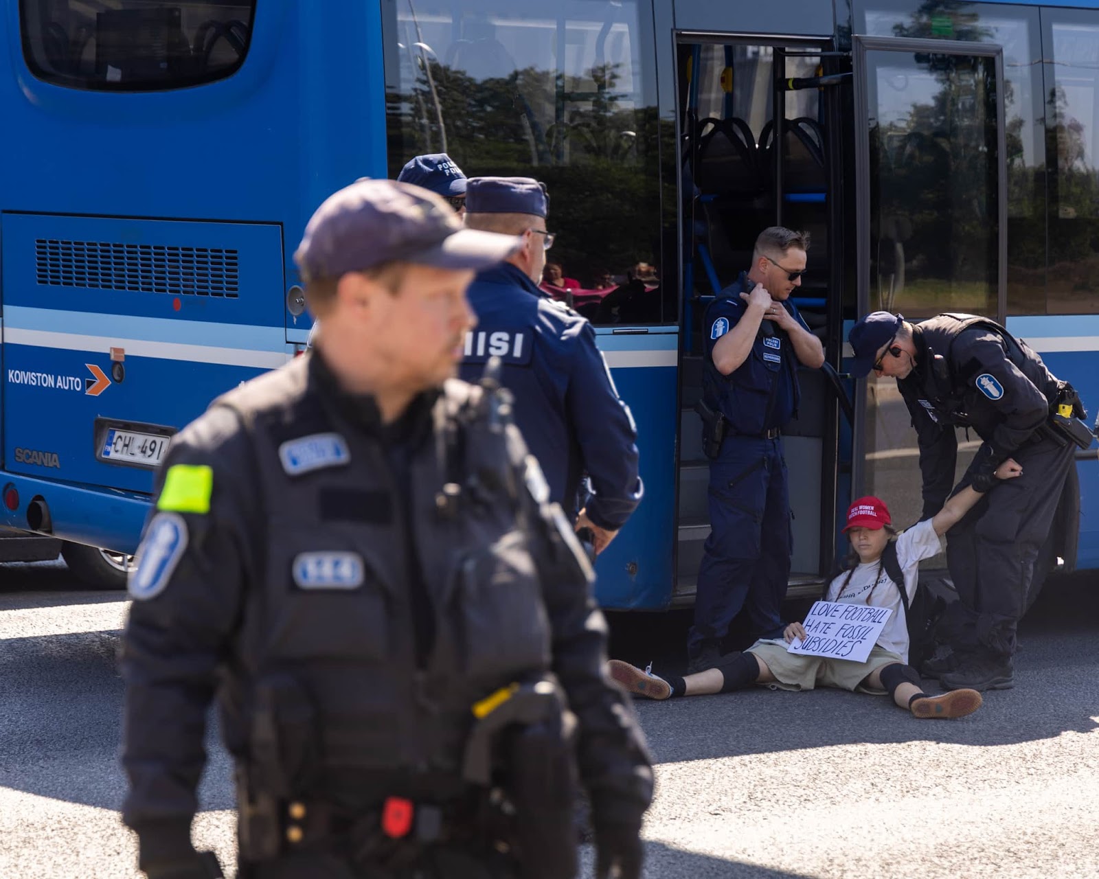 A rebel is dragged by police into a waiting police bus