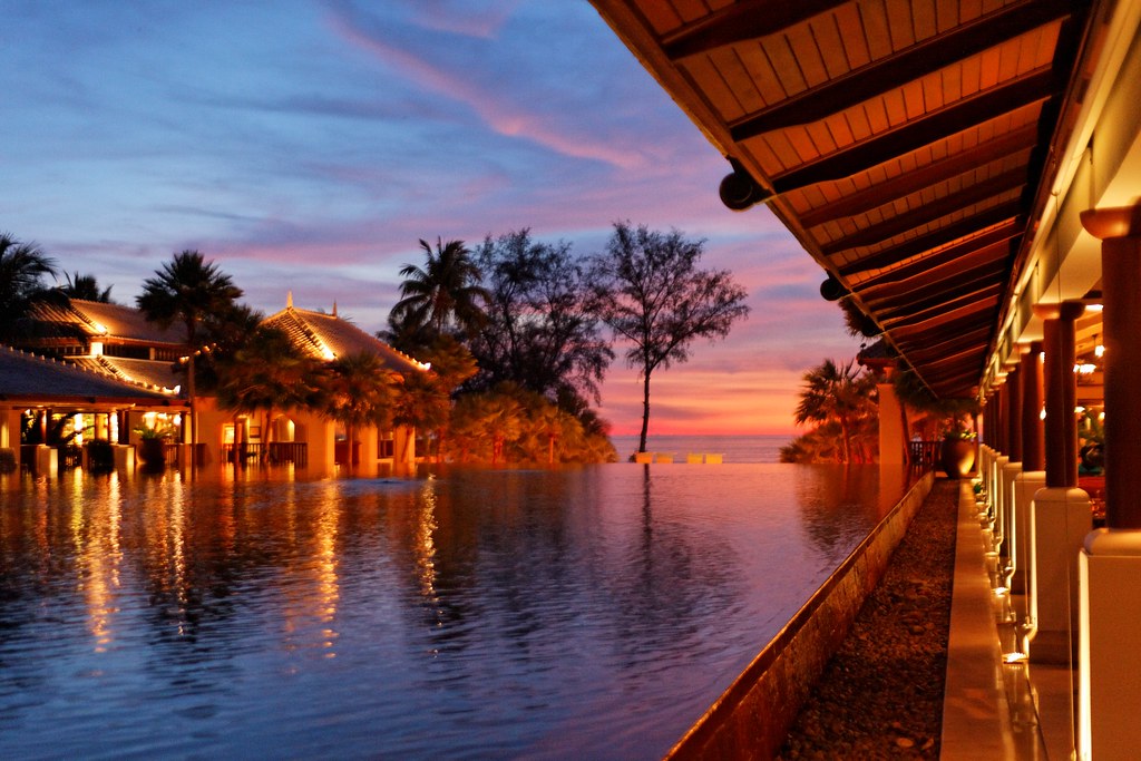 Night scene with illuminated water and lights reflecting around a resort.