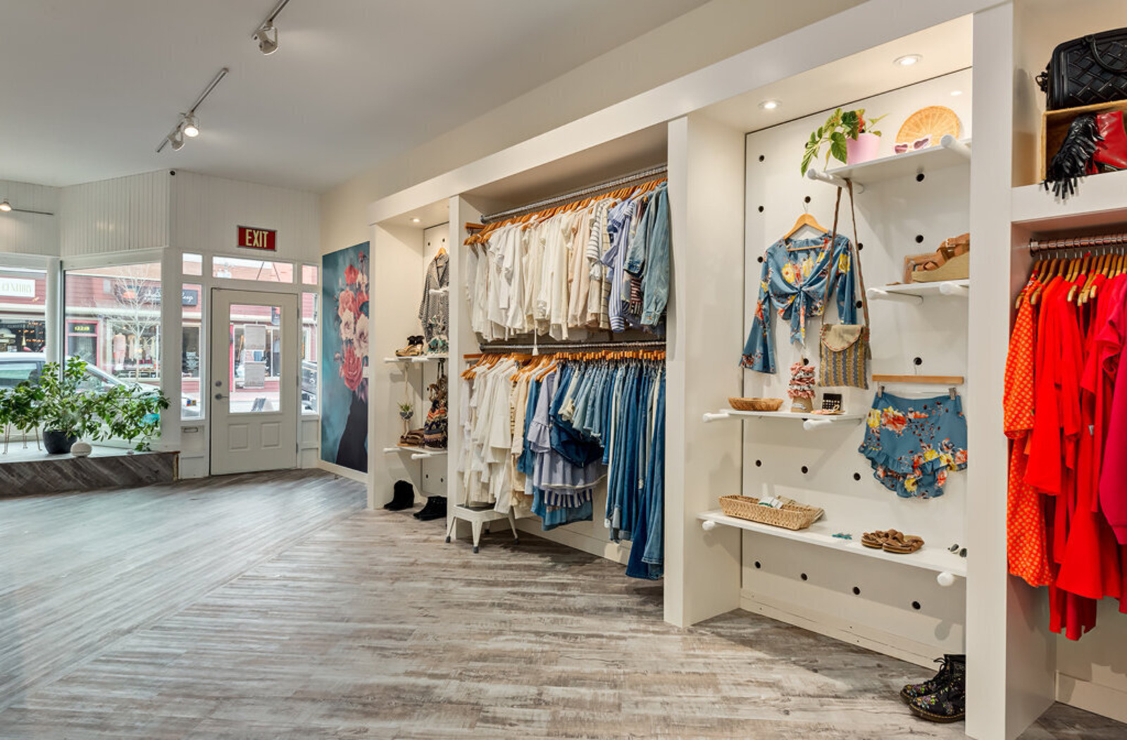 A wide-angle view of the front entrance of The Peacock Boutique's Inglewood location with patterned clothing hanging up.