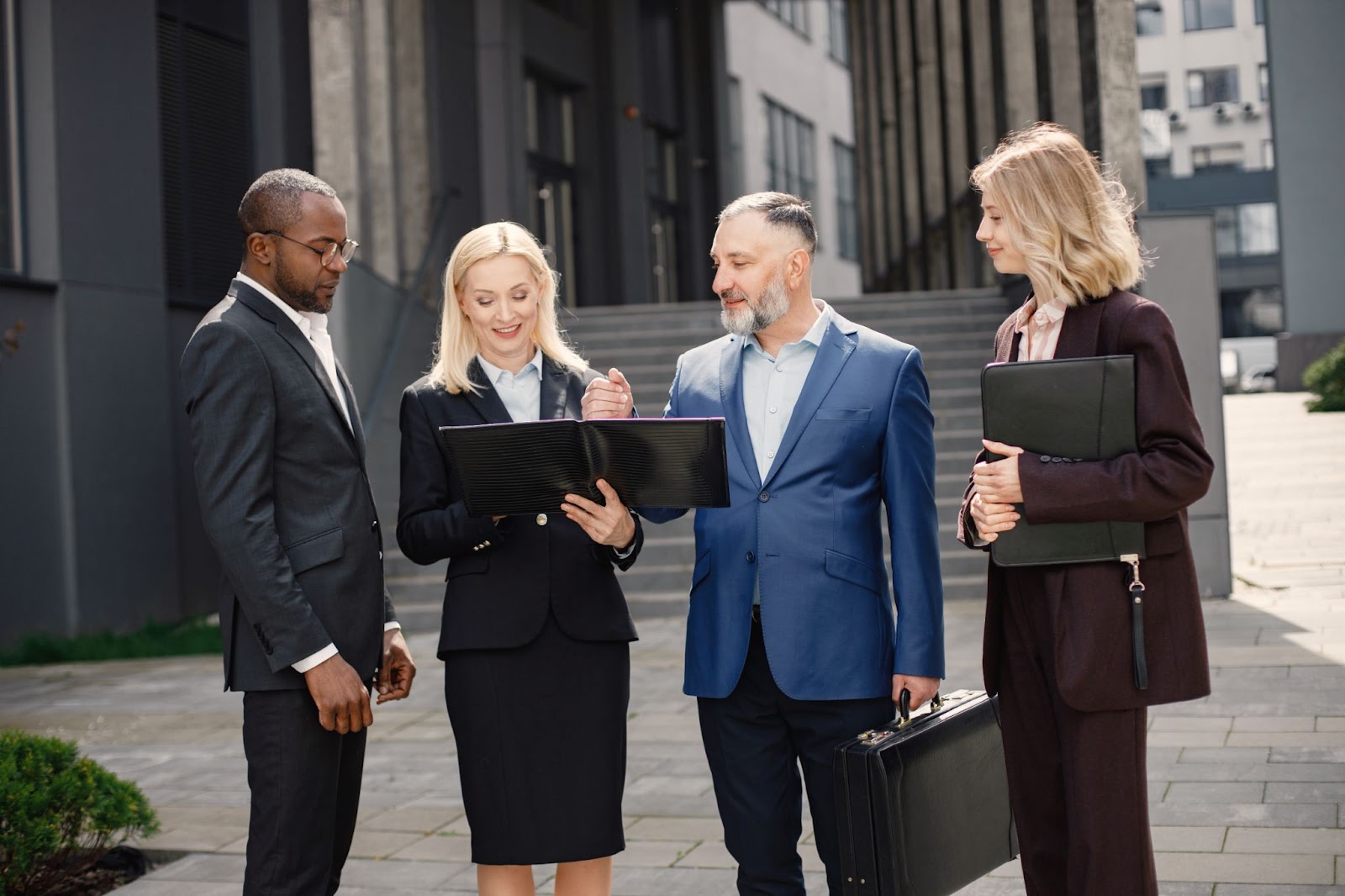 A group of business professionals study procedures outside.