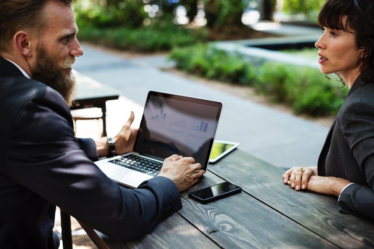 Crypto asset investment consultantsdiscussing charts on a laptop.