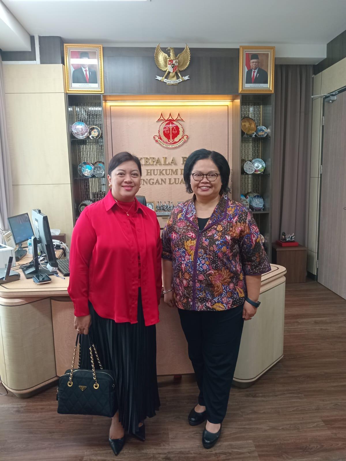 Two women standing in front of a deskDescription automatically generated