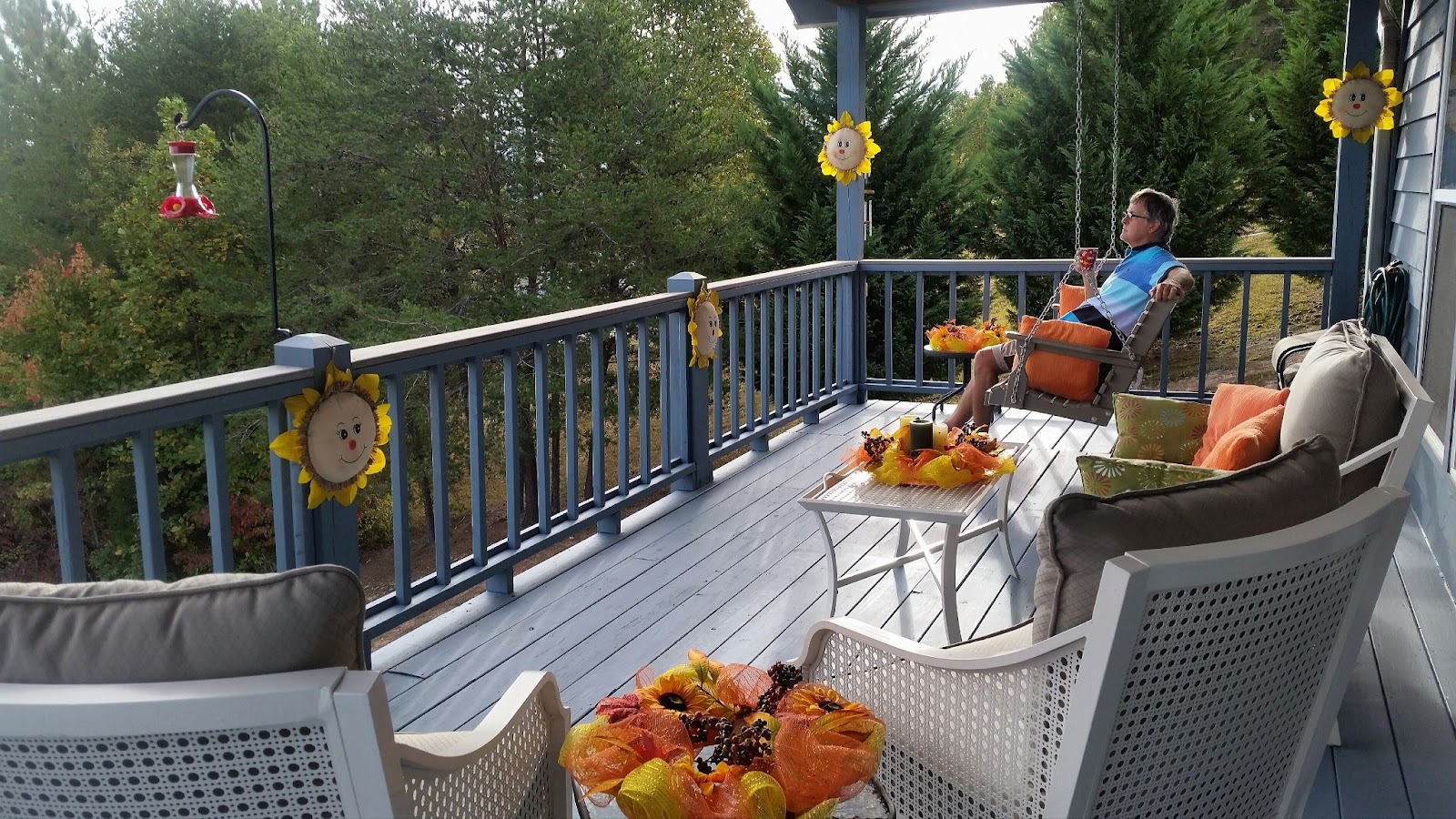 A man enjoying the morning air while sipping a cup of coffee on the balcony. 