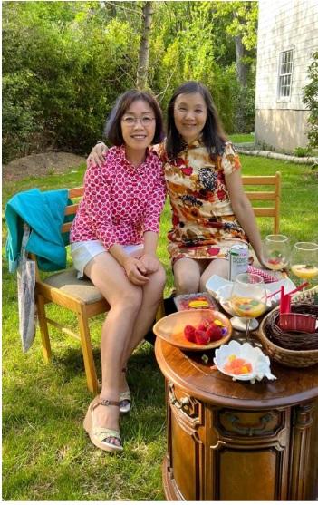 Two women sitting on chairs in a yard

Description automatically generated