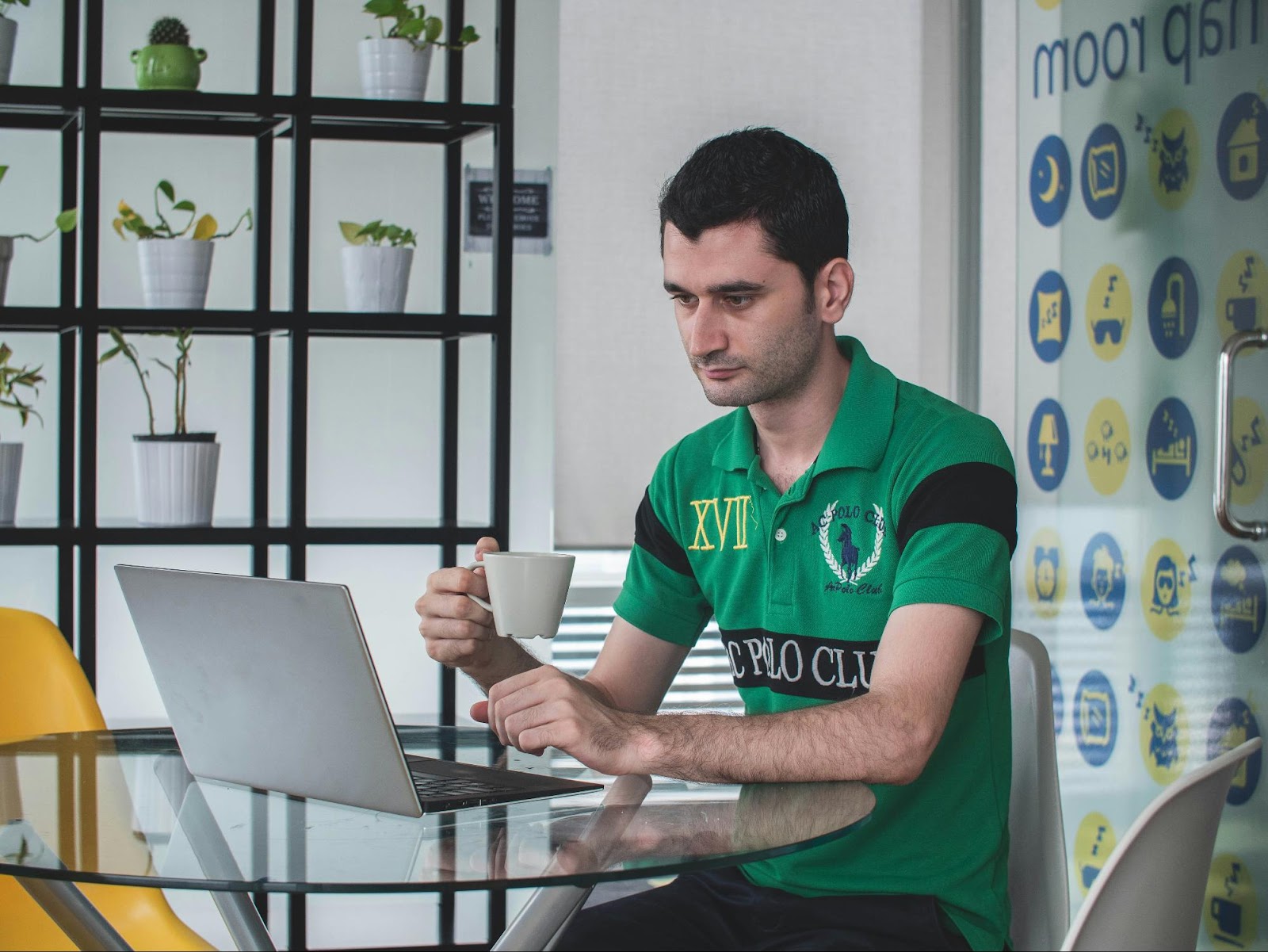 a man holding a cup and a laptop
