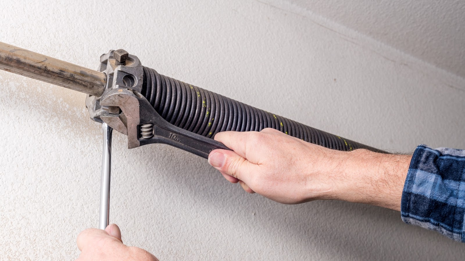 A technician adjusting the garage door spring
