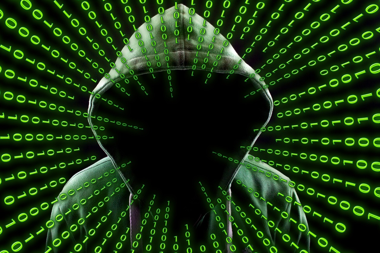 A hooded figure with a faceless black void, surrounded by streaming green binary code.