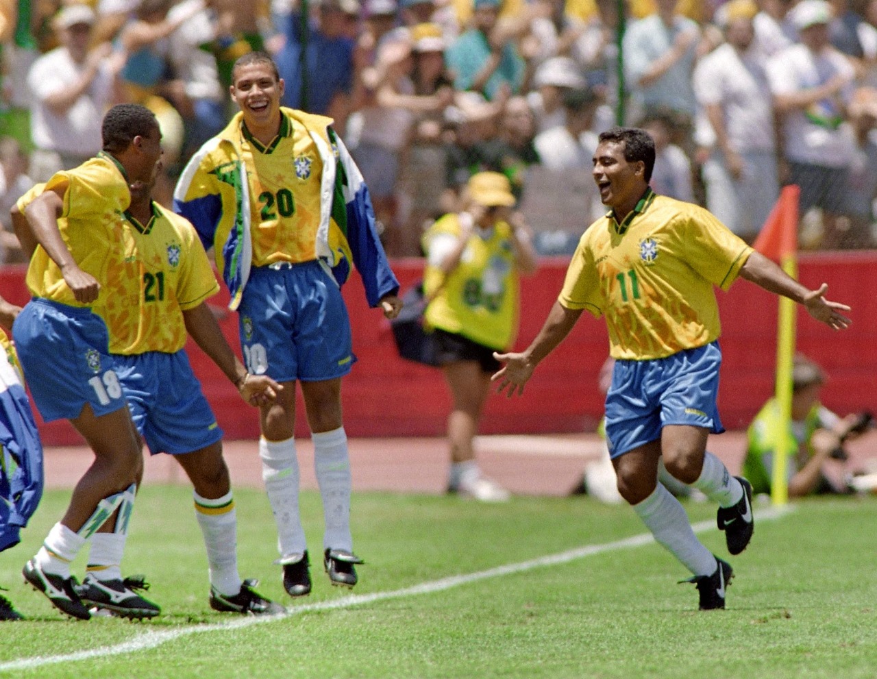 Romário comemorando gol na Copa do Mundo de 1994 com o banco do Brasil, como Ronaldo Fenômeno e outros jogadores