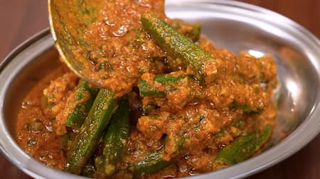 Fried bhindi being mixed into the thickened gravy in the final preparation step of Bhindi Masala.