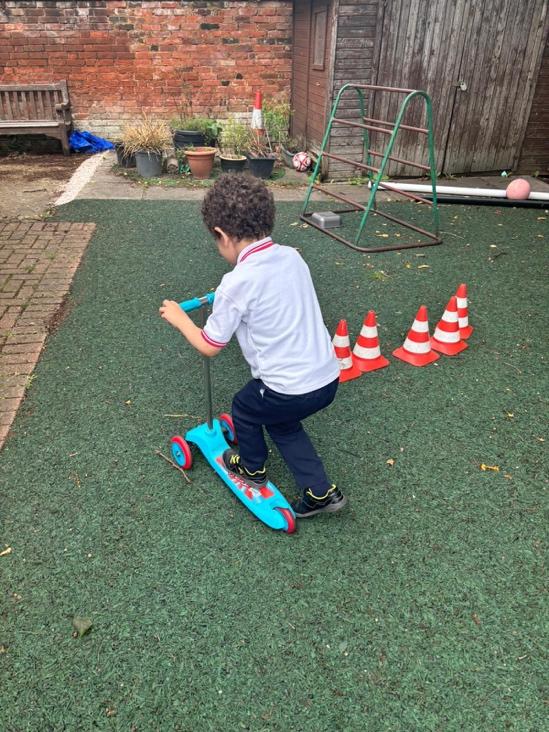 A child on a scooter

Description automatically generated