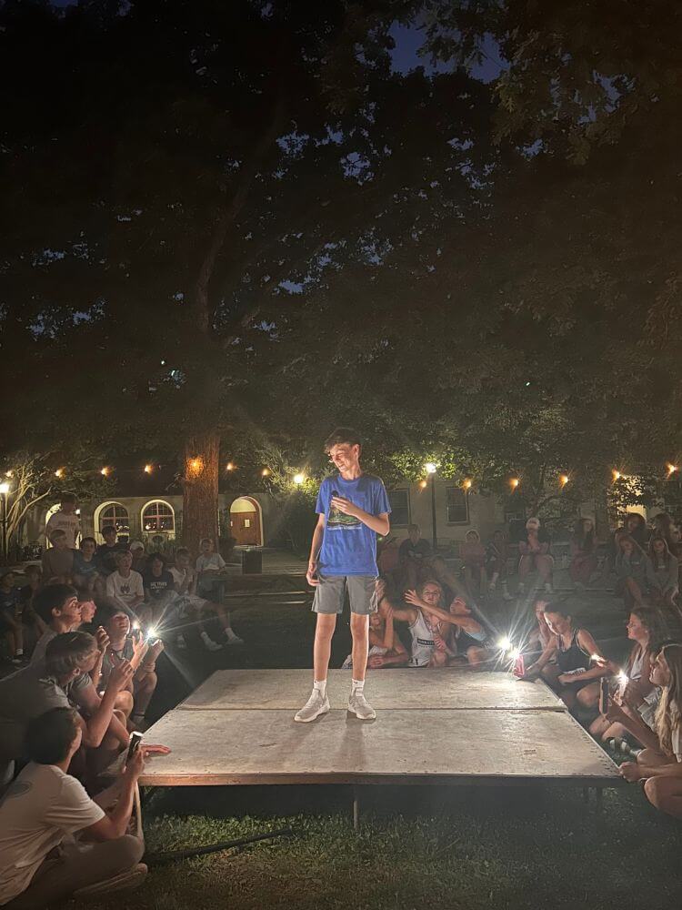 Camper at Signature Sports Camp is on stage during camp games for a Shark Tank pitch