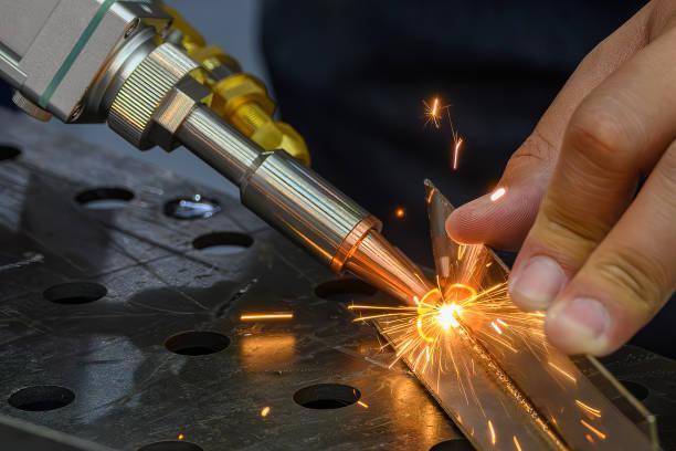 Close up scene the laser welding process by hand held laser welding machine. Close up scene the laser welding process by hand held laser welding machine. The high technology welding process by laser welding machine. laser welding stock pictures, royalty-free photos & images