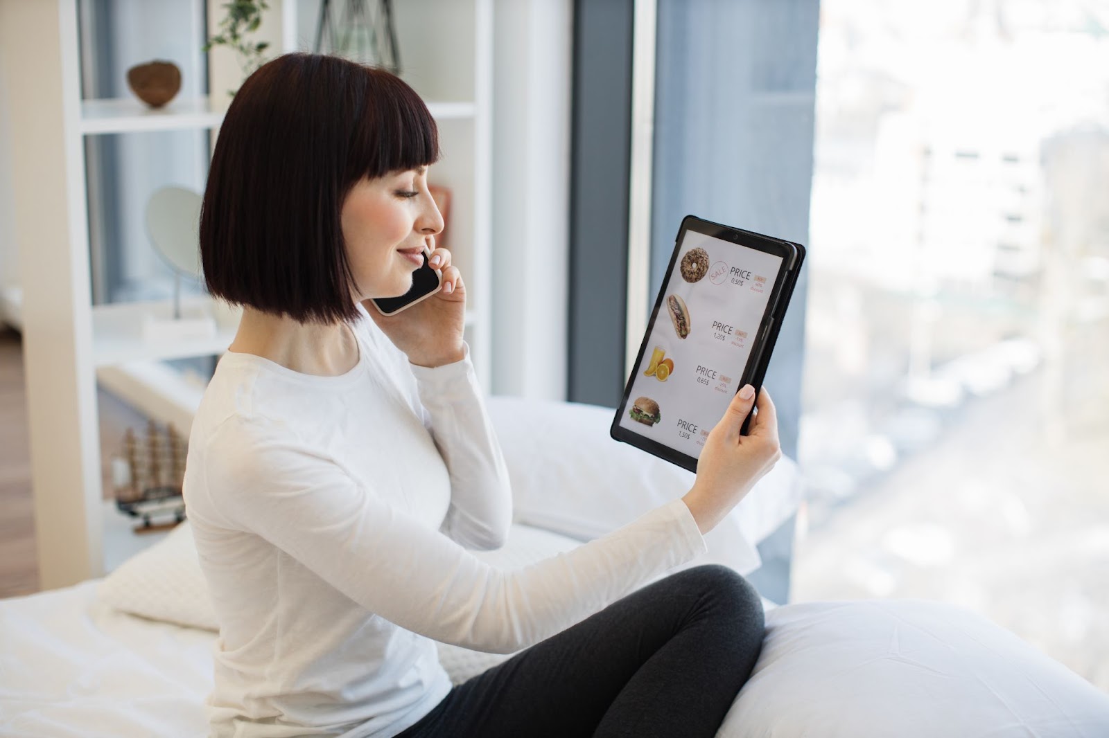 Mulher com tablet e celular pedindo comida