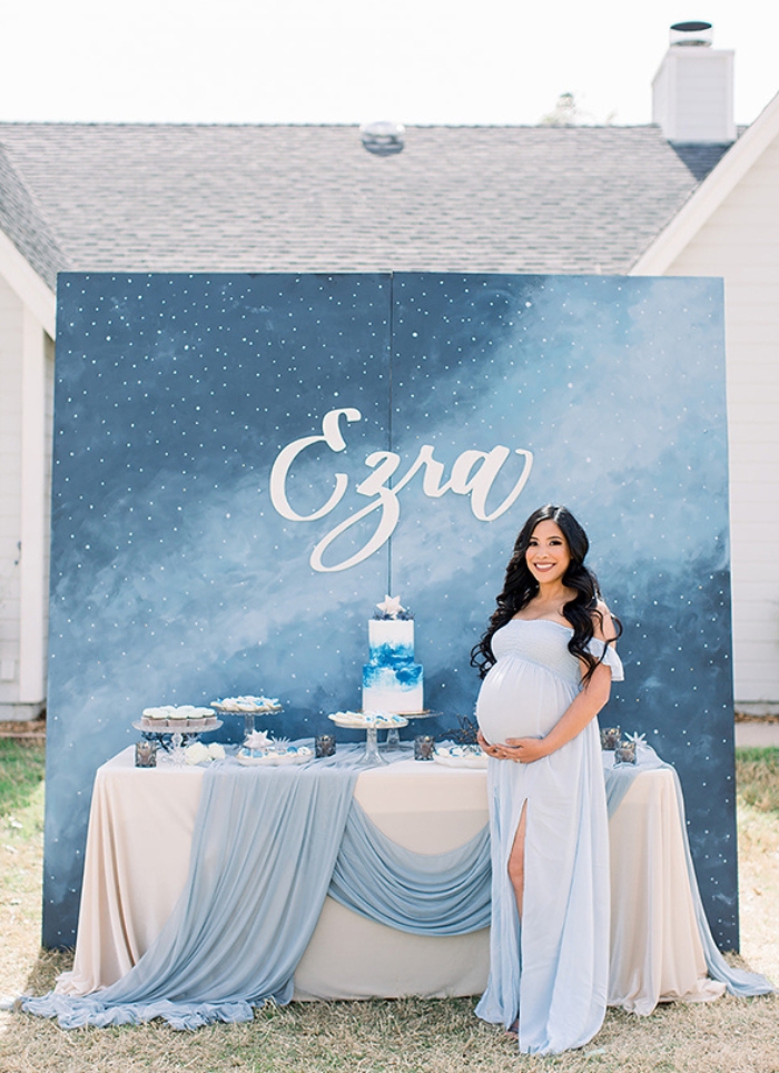 pregnant woman standing in front of food table at baby shower