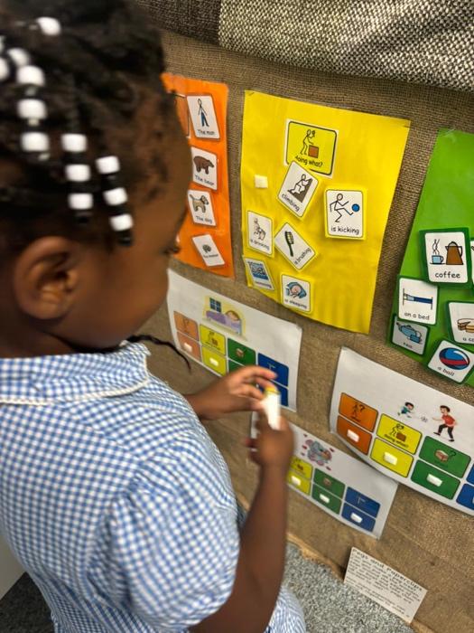 A child writing on a bulletin board

Description automatically generated