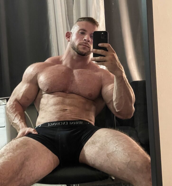 Cody Mac posing shirtless in black armani exchange boxer briefs showing off his gay muscled pecs and veiny muscled legs in gay xxx onlyfans photo