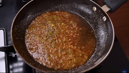 Ghee heating in a pan with cumin seeds and asafoetida for tempering.