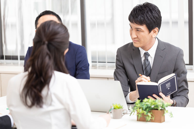 会議する3人の人物