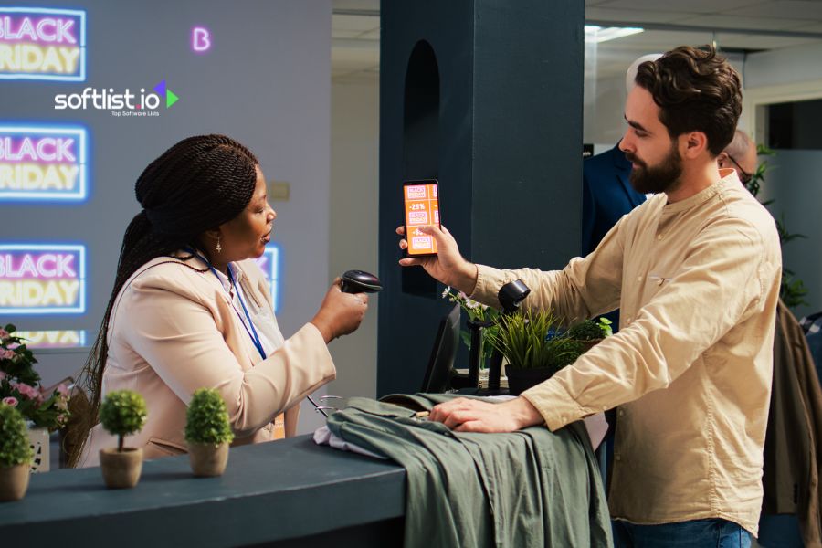 Customer shows Black Friday deals on phone to cashier for scanning.