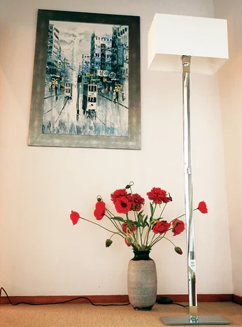 contemporary style chrome floor lamp with white lampshade in a room