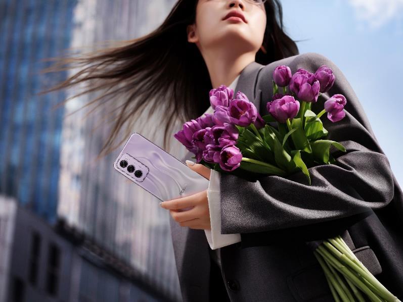 A person holding flowers and a phone

Description automatically generated