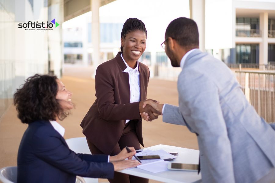 Business professionals shaking hands during an outdoor meeting.