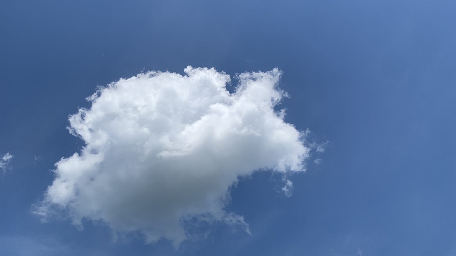 A nice little scraggly puffball of a cloud on blue sky