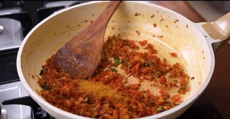 Chopped tomatoes and spices added to the sautéed onions.