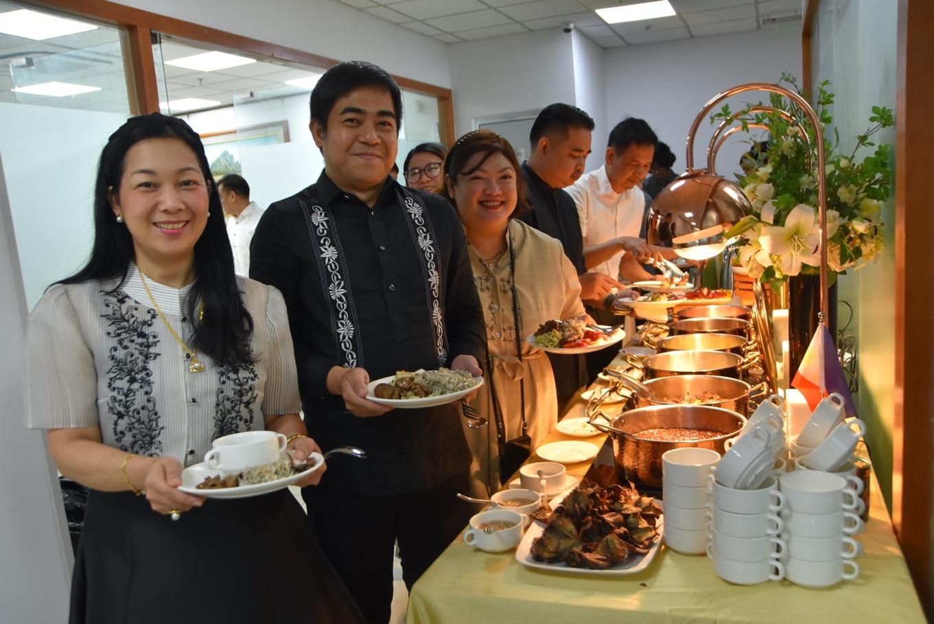 A group of people standing in front of a buffet tableDescription automatically generated