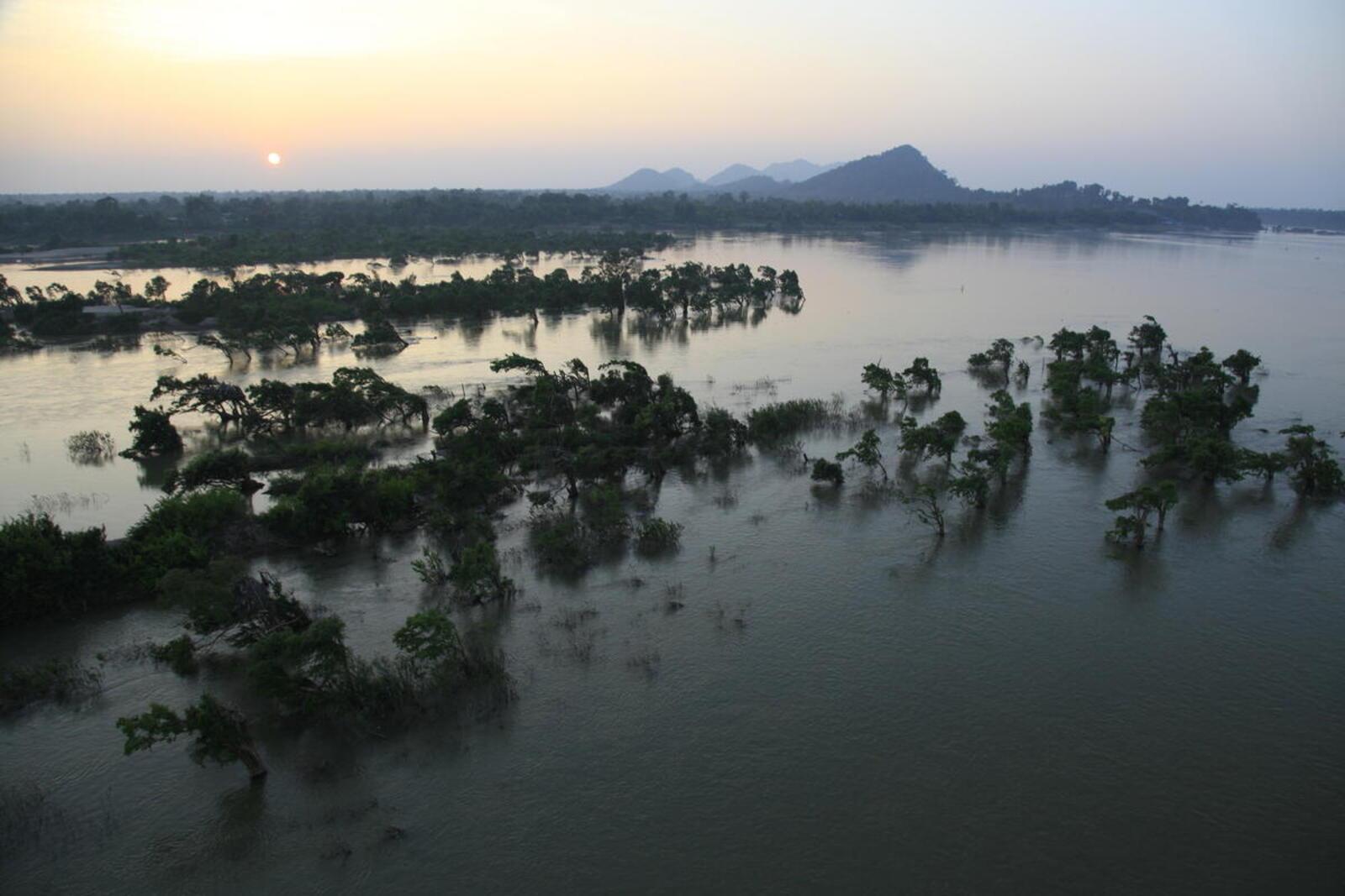 Aerial of sunset, with islets in front and misty mountains at the back, Cambodia