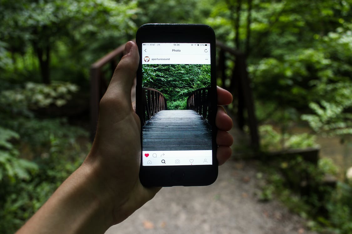 Free Person Holding Smartphone Taking Picture of Bridge during Daytime Stock Photo