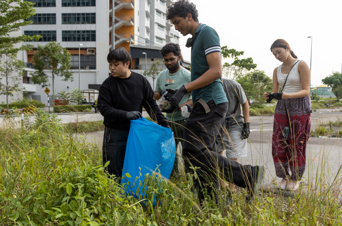 A group of people picking up garbage

Description automatically generated