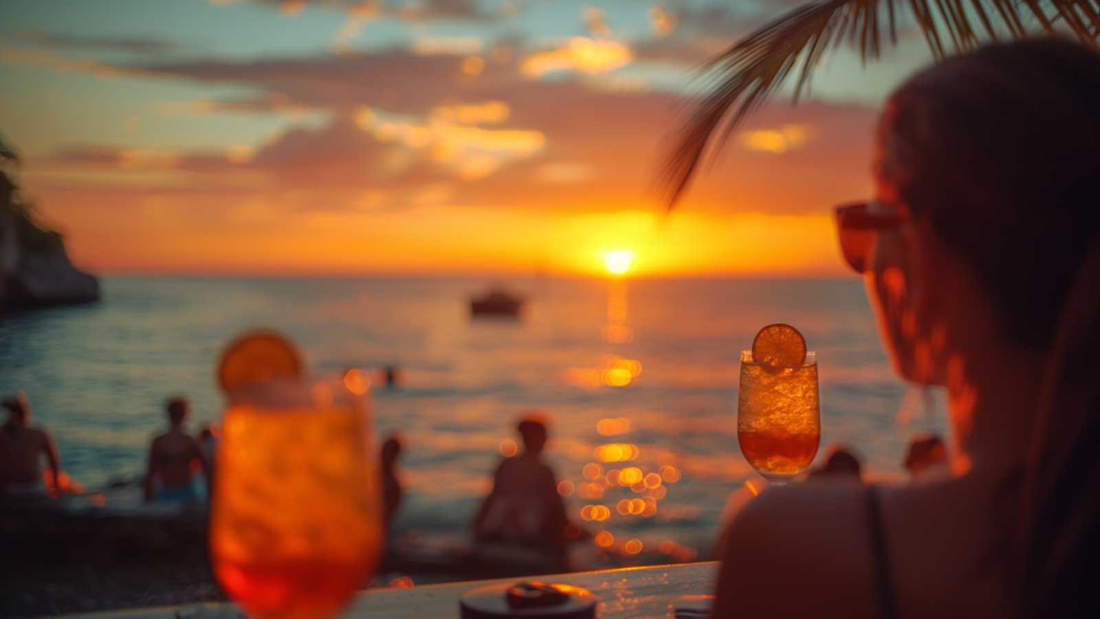 Guests relax with cocktails at a beach club during a tranquil sunset in Playa del Carmen.